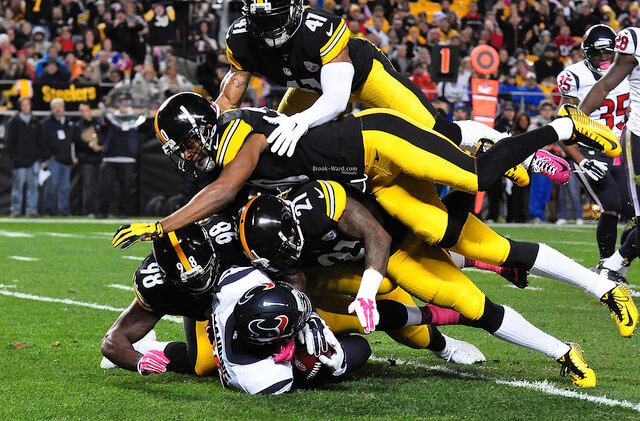 Several Steelers defenders tackle a Texans ball-carrier
