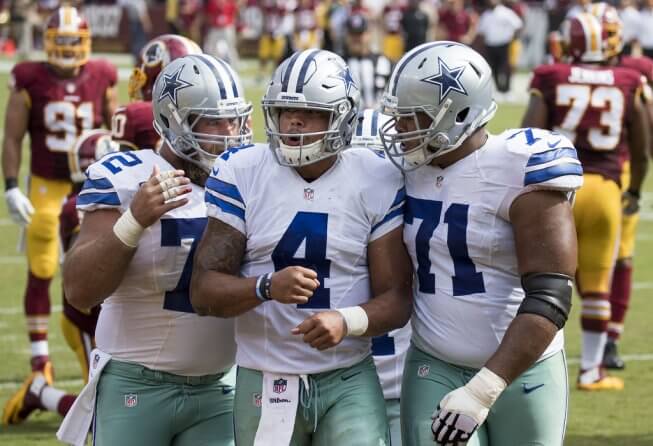 Cowboys QB Dak Prescott celebrating with his offensive linemen.