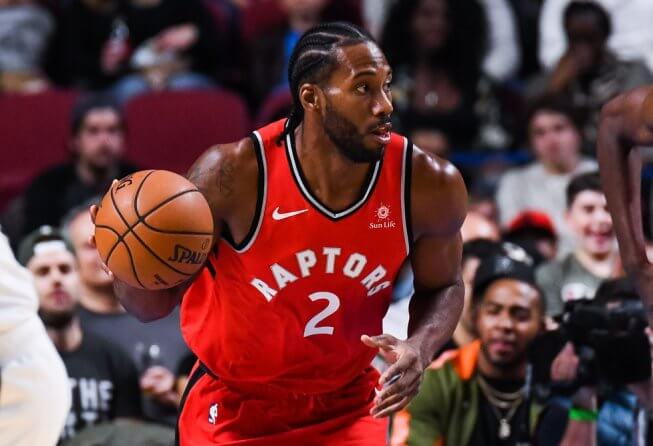 Kawhi Leonard dribbles the ball up the court.