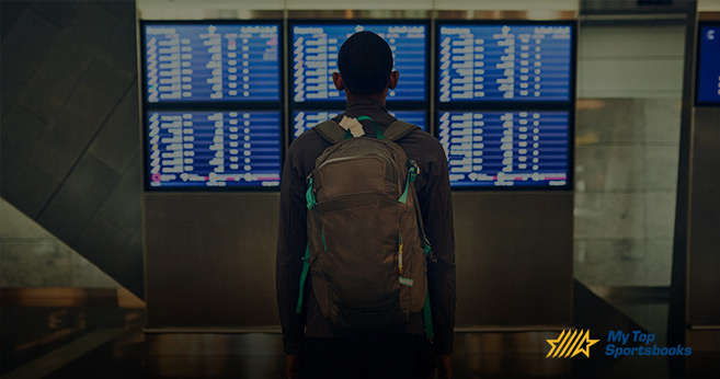 back of a soccer player looking at flight times board