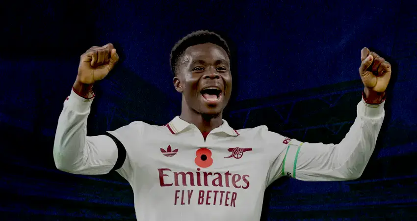 Arsenal player Saka celebrating a goal on the champions league tournament